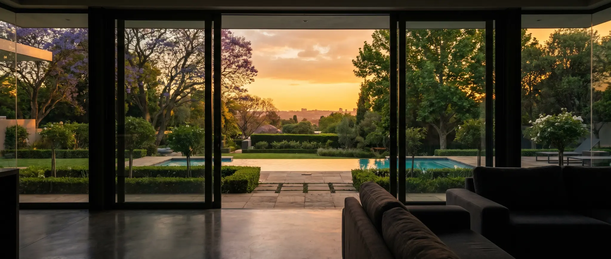 Luxury estate with pool overlooking Johannesburg sunset through floor-to-ceiling windows